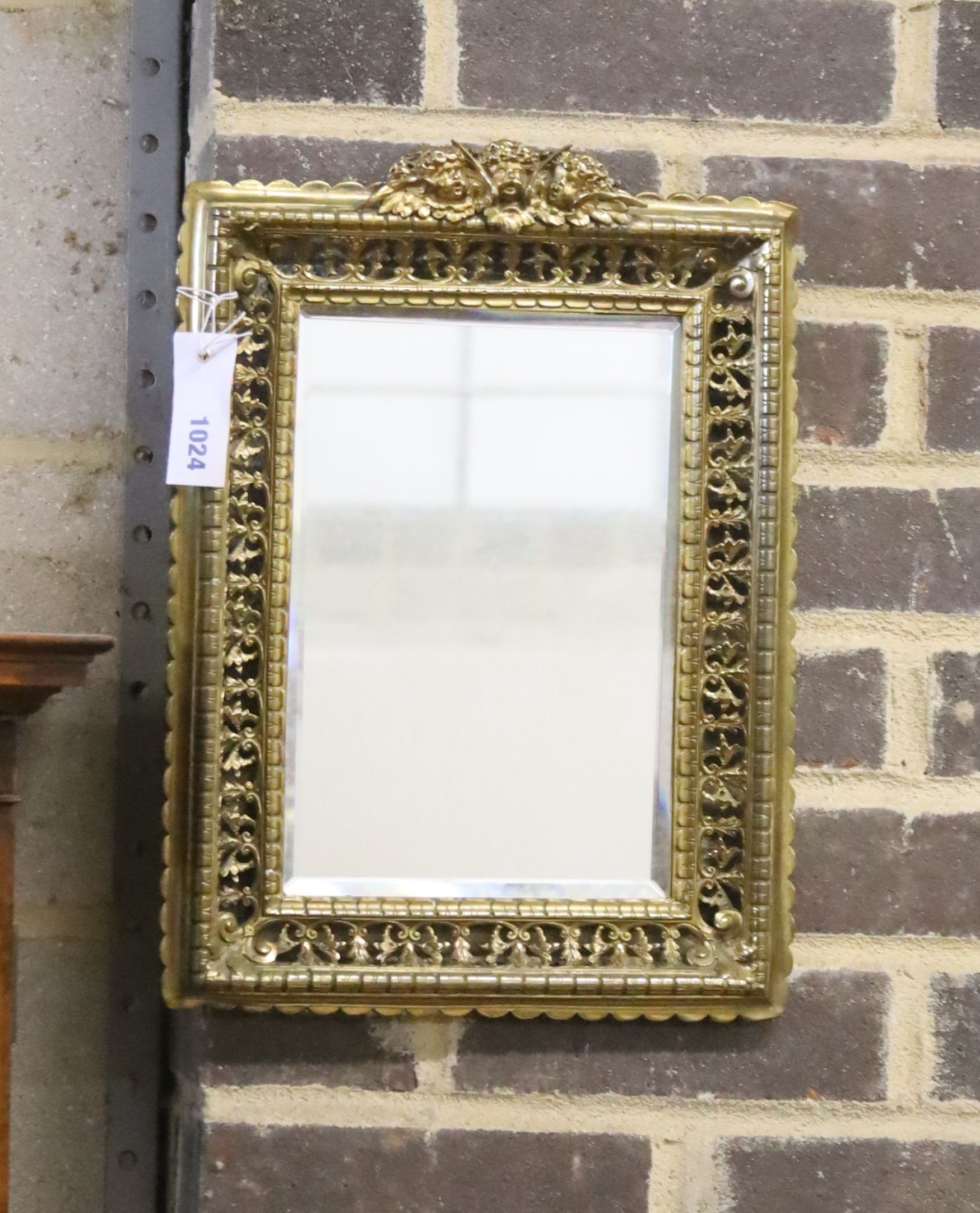 An early 20th century rectangular pierced brass wall mirror with cherub pediment, width 29cm, height 40cm